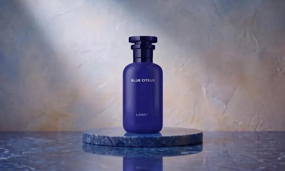 A sleek, deep blue "BLUE CITRUS" perfume bottle by LANSY, displayed on a blue marble