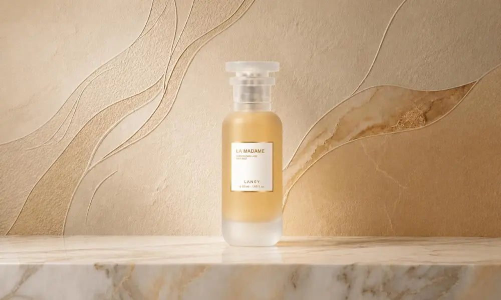 A central, frosted-glass perfume bottle labeled "LA MADAME" by LANSY, resting on a marble surface in front of an intricate, multi-textured wall with swirling relief patterns in beige, tan, and light green.