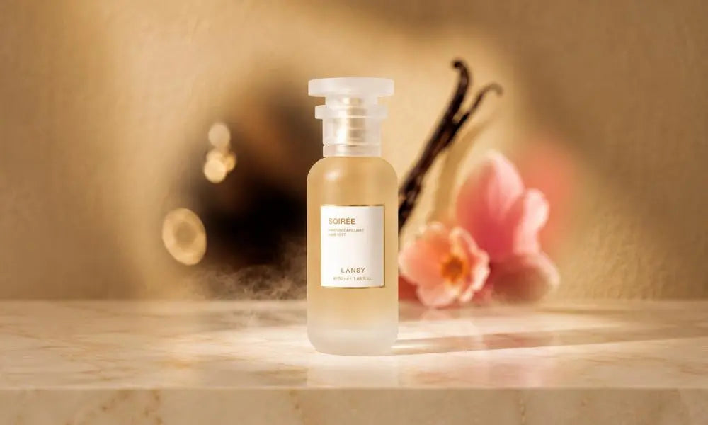 A frosted glass perfume bottle labeled "SOIRÉE LANSY" stands on a beige marble surface, illuminated by a focused spotlight against a warm, softly blurred background.