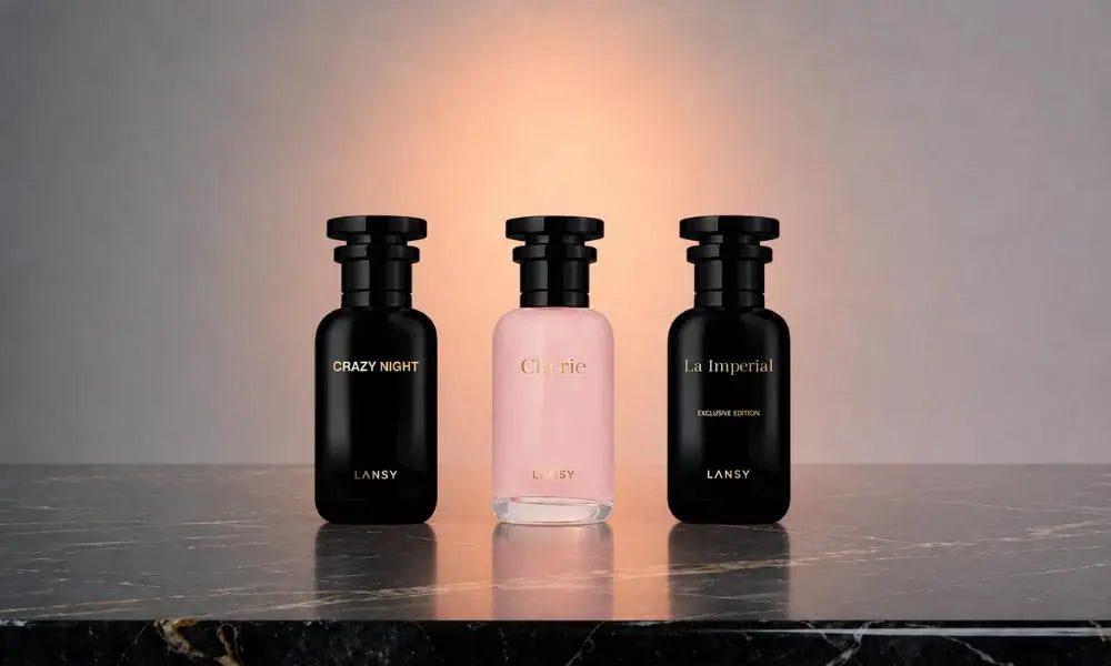 Three elegant perfume bottles with gold branding, arranged side-by-side on a polished marble surface, reflecting the warm glow of the background.