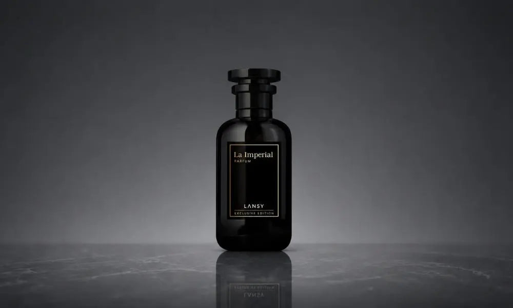 A sleek black perfume bottle labeled "La Imperial" sits centered on a dark marble surface against a moody grey background.