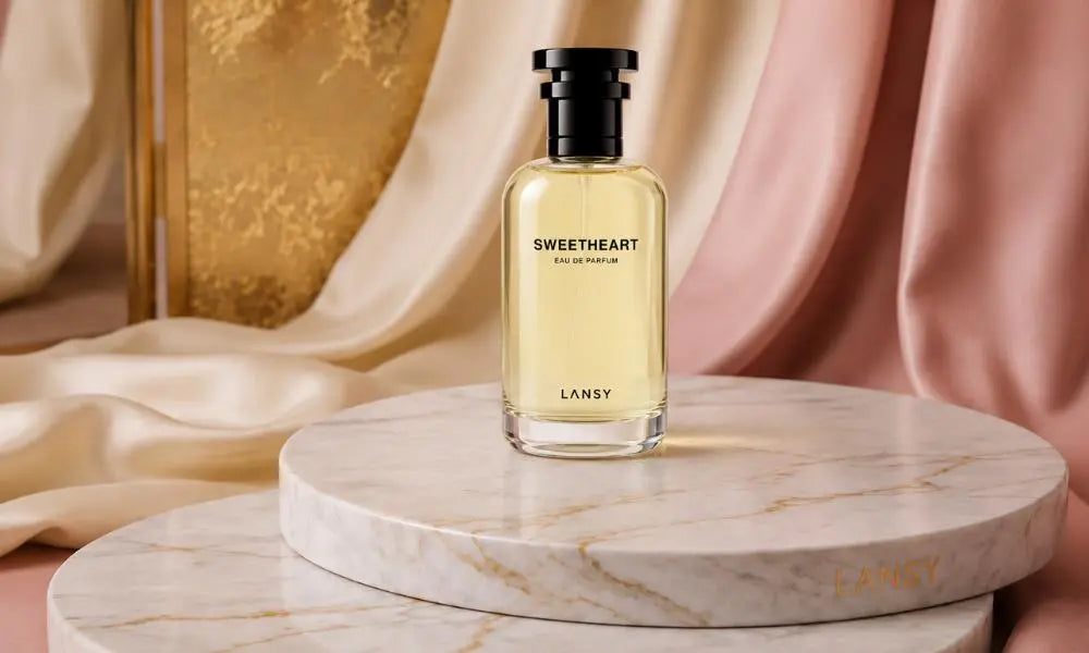 Elegant Sweetheart Eau de Parfum bottle displayed on a marble pedestal with soft satin drapes and a luxurious warm-toned background.
