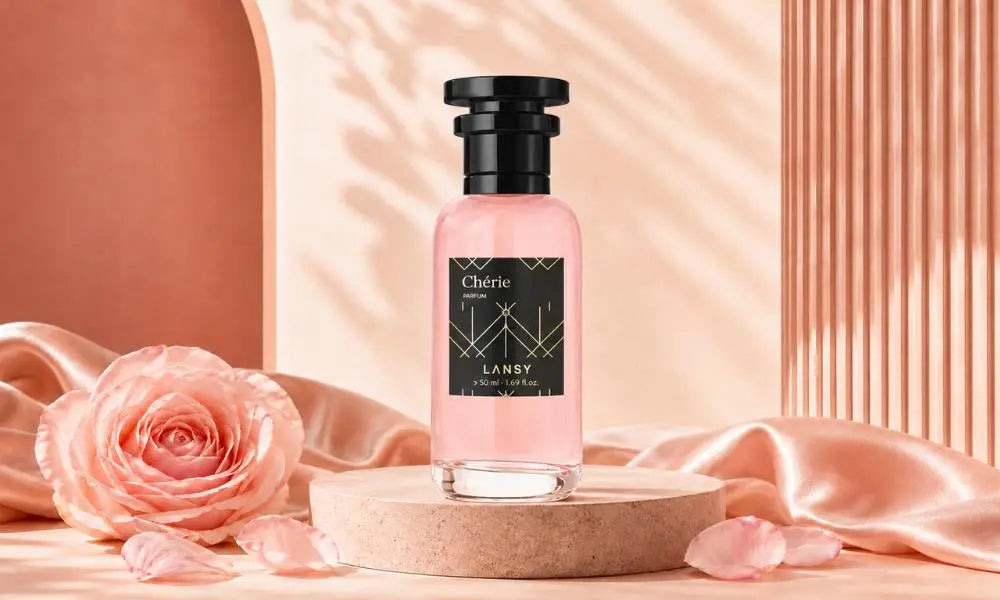 a perfume bottle with pink liquid on a white marble stand, next to a white card with a gold line drawing.