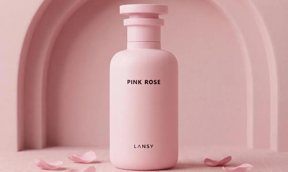 LANSY Pink Rose perfume bottle on arched pink background with scattered petals.