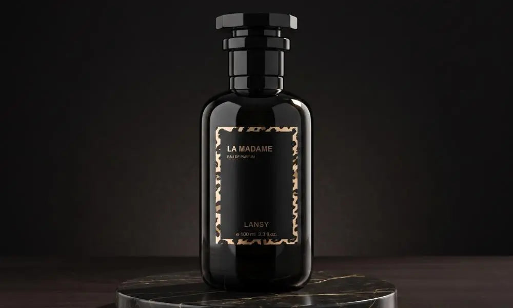 A black perfume bottle branded "LA MADAME" by LANSY, resting on a dark marble pedestal.