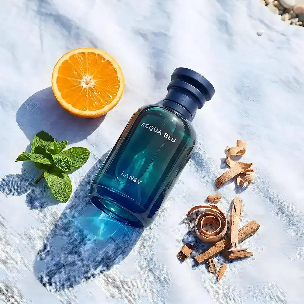 Lansy Acqua Blu bottle with an orange, mint leaves, and cinnamon sticks on a textured surface