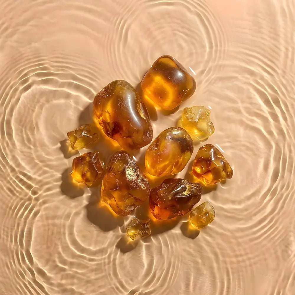 Amber-colored stones on a sandy surface with ripples