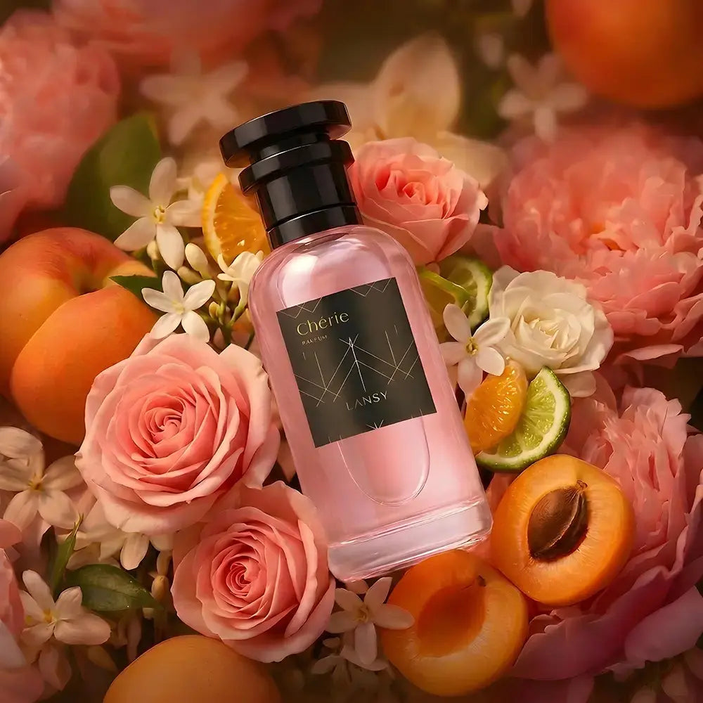 LANSY Cherie Parfum bottle surrounded by pink roses, white flowers, apricots and citrus fruits.
