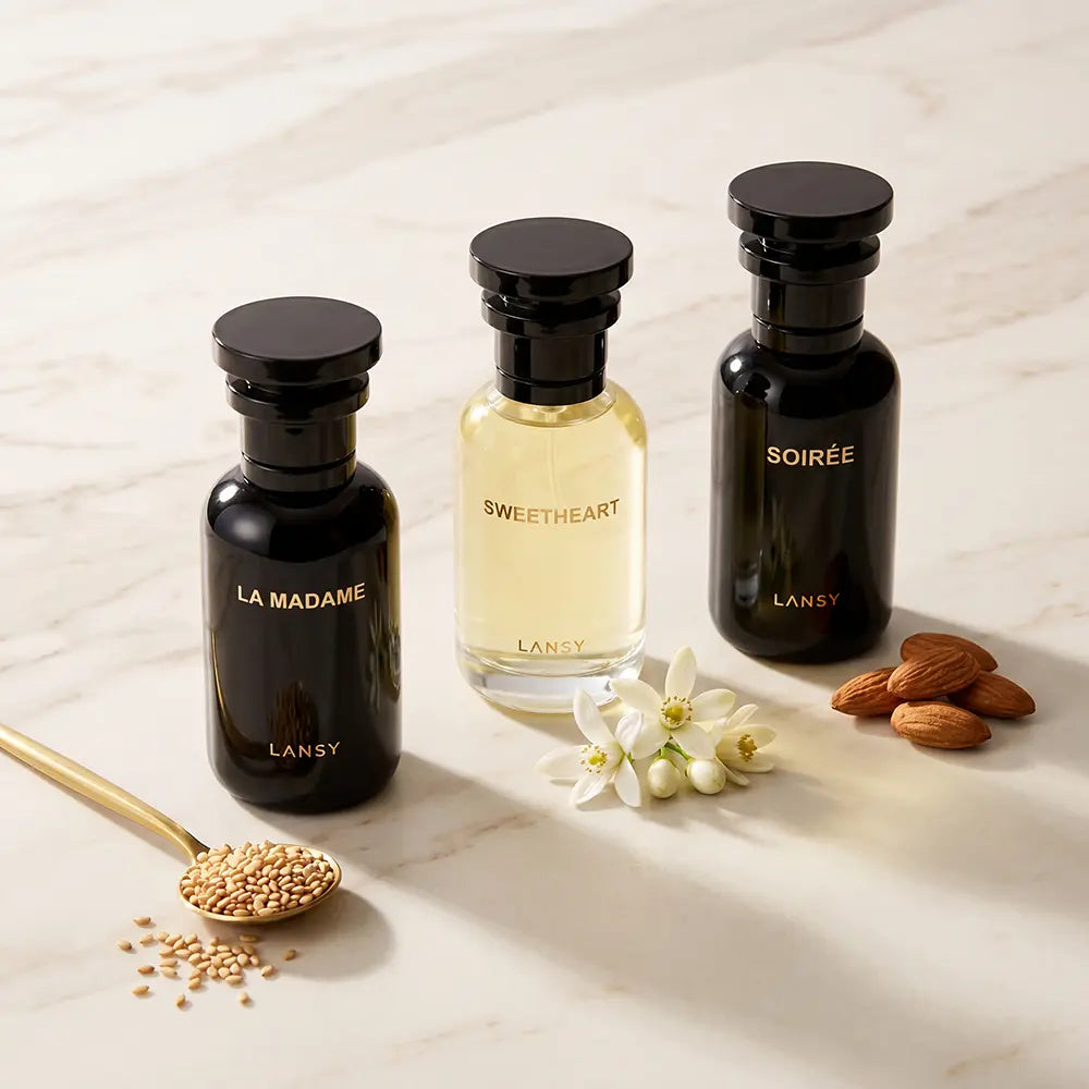 LANSY La Madame, Sweetheart and Soirée perfume bottles with seeds and almonds on a marble surface.