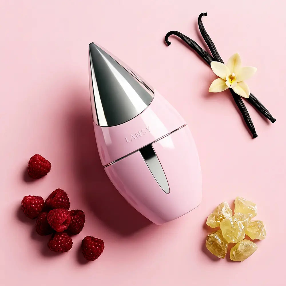 LANSY Taleen pink perfume bottle with raspberries, vanilla beans and amber crystals on a pink background.
