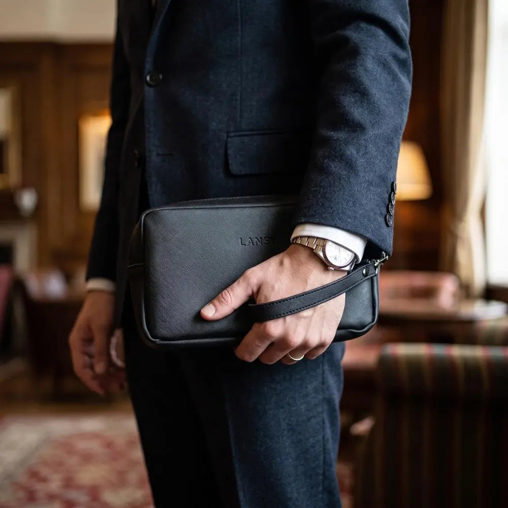 LANSY black leather crossbody clutch bag styled with a dark navy suit.