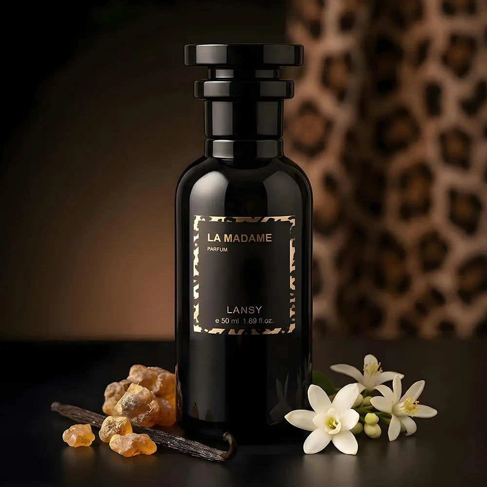 Black LANSY perfume bottle with flowers and vanilla beans on a dark background