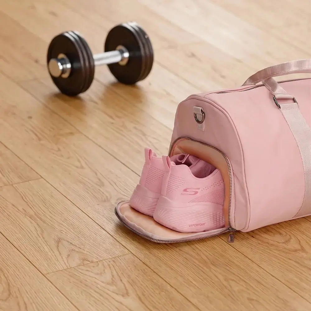 Pink shoe in a duffel bag on a wooden floor with a dumbbell nearby