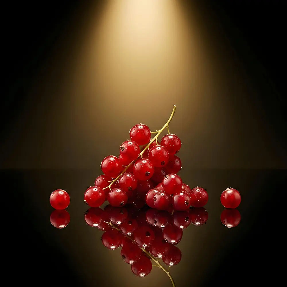 Bunch of red berries on a reflective surface with a dark background