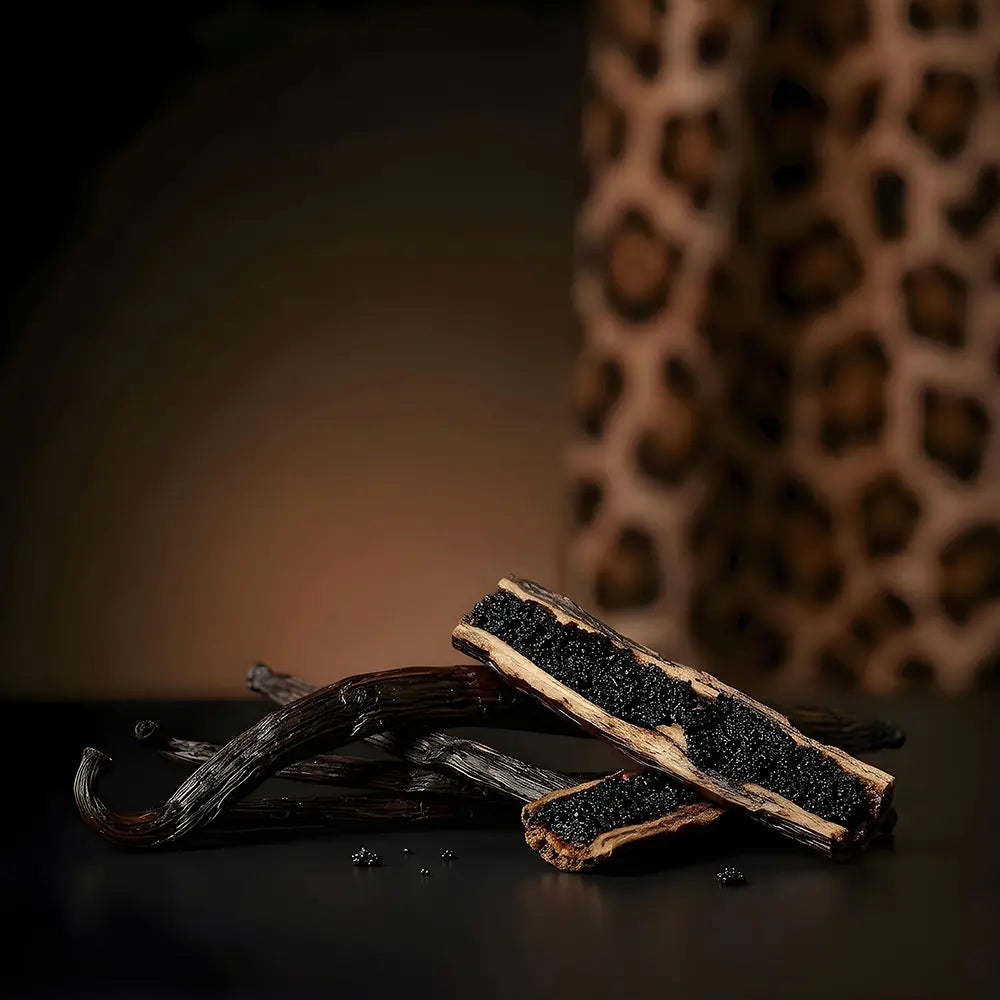 Vanilla beans on a dark surface with a blurred leopard print background.